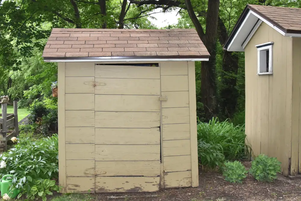 The west face of the Kibbee Farmstead shed in Douglas County, Kansas, with horizontal shiplap and visible paint wear at the base. A historic example, not a model installation detail.